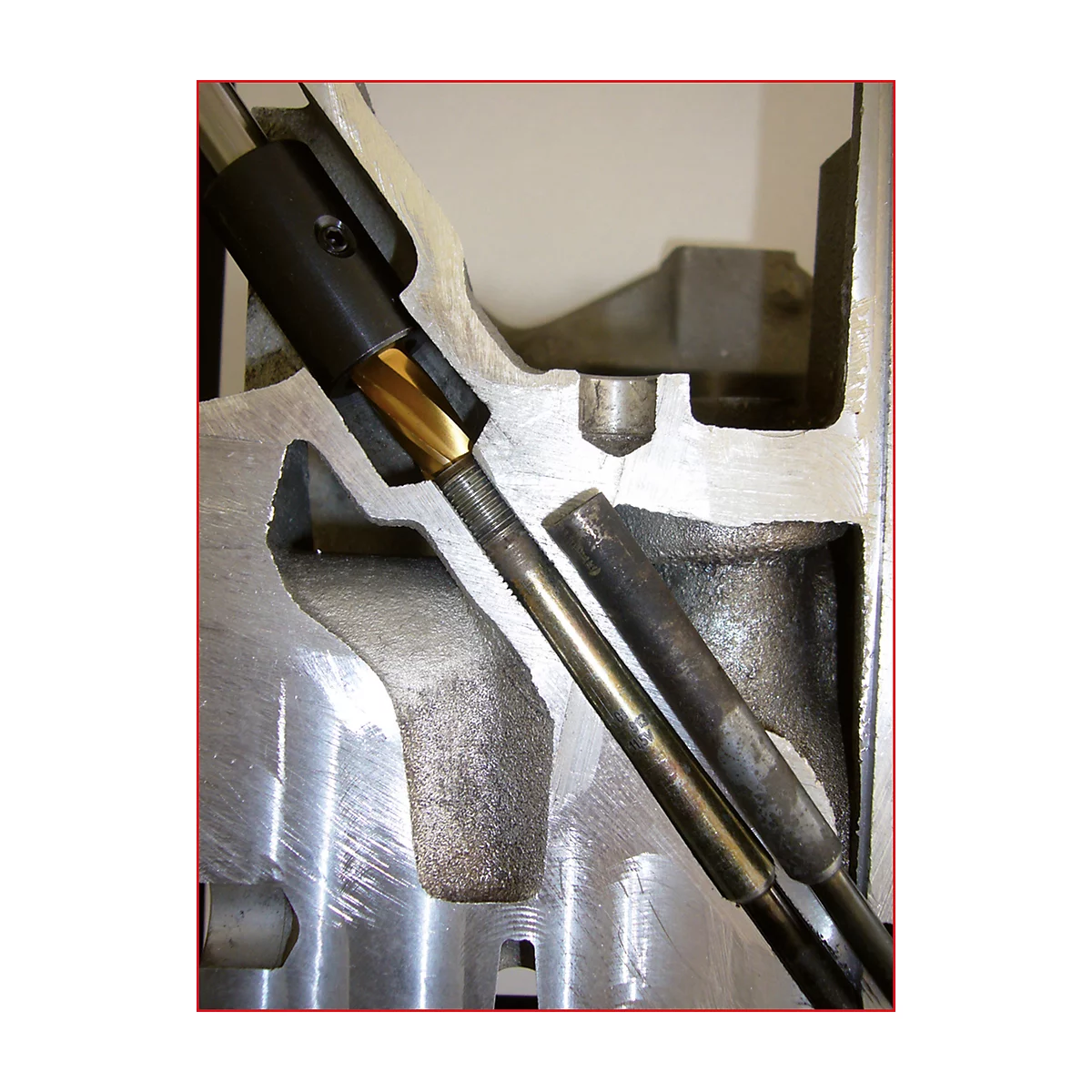 Nahaufnahme einer Maschine mit Bohrer und Metallteilen. Der Bohrer dringt in das Metall ein.